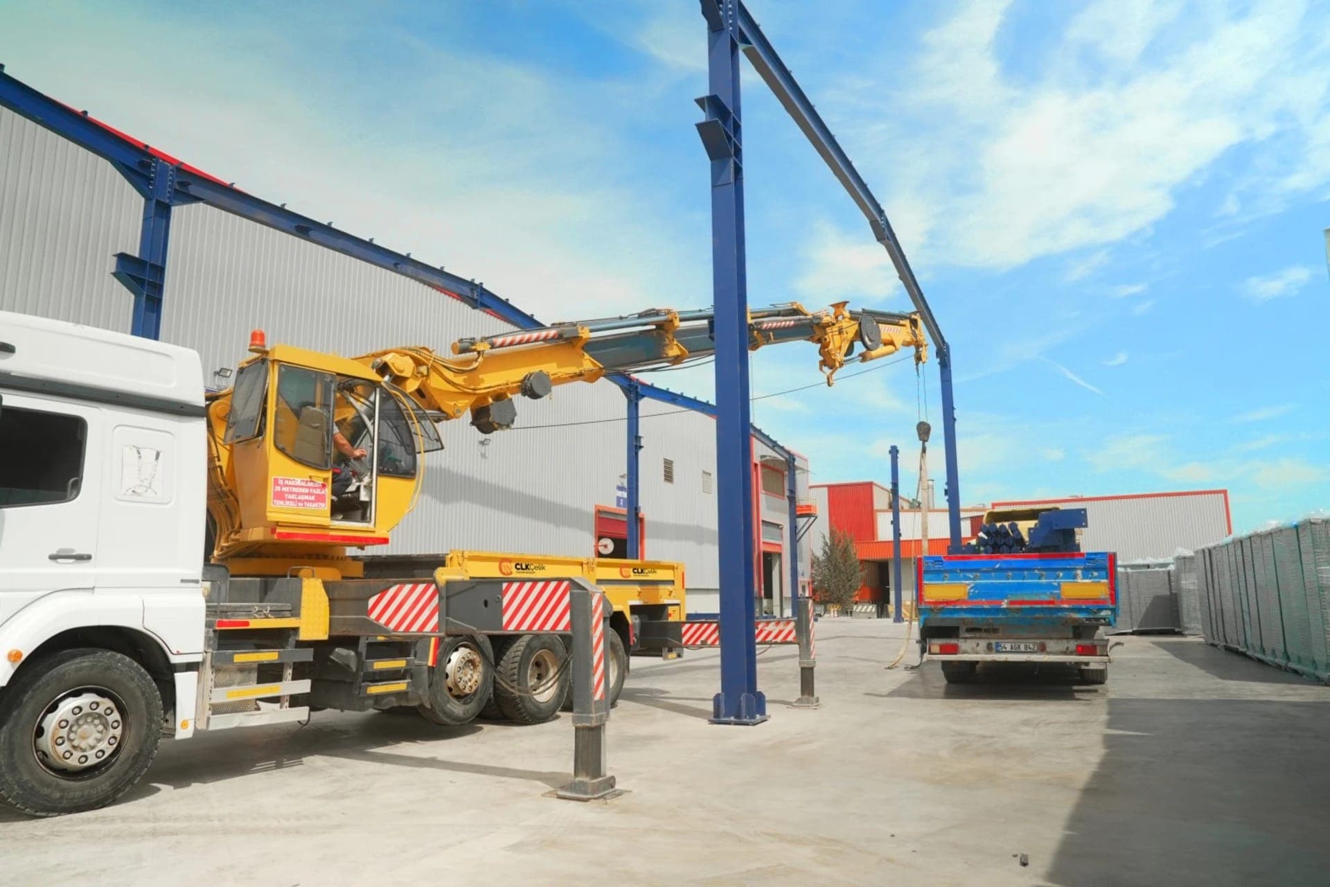 Монтаж на стоманени конструкции: работник с каска работи върху стоманена греда; безопасна конструкция с висока носеща способност.